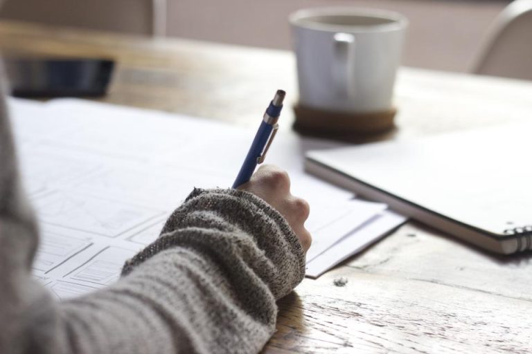 A hand writing notes in a notebook